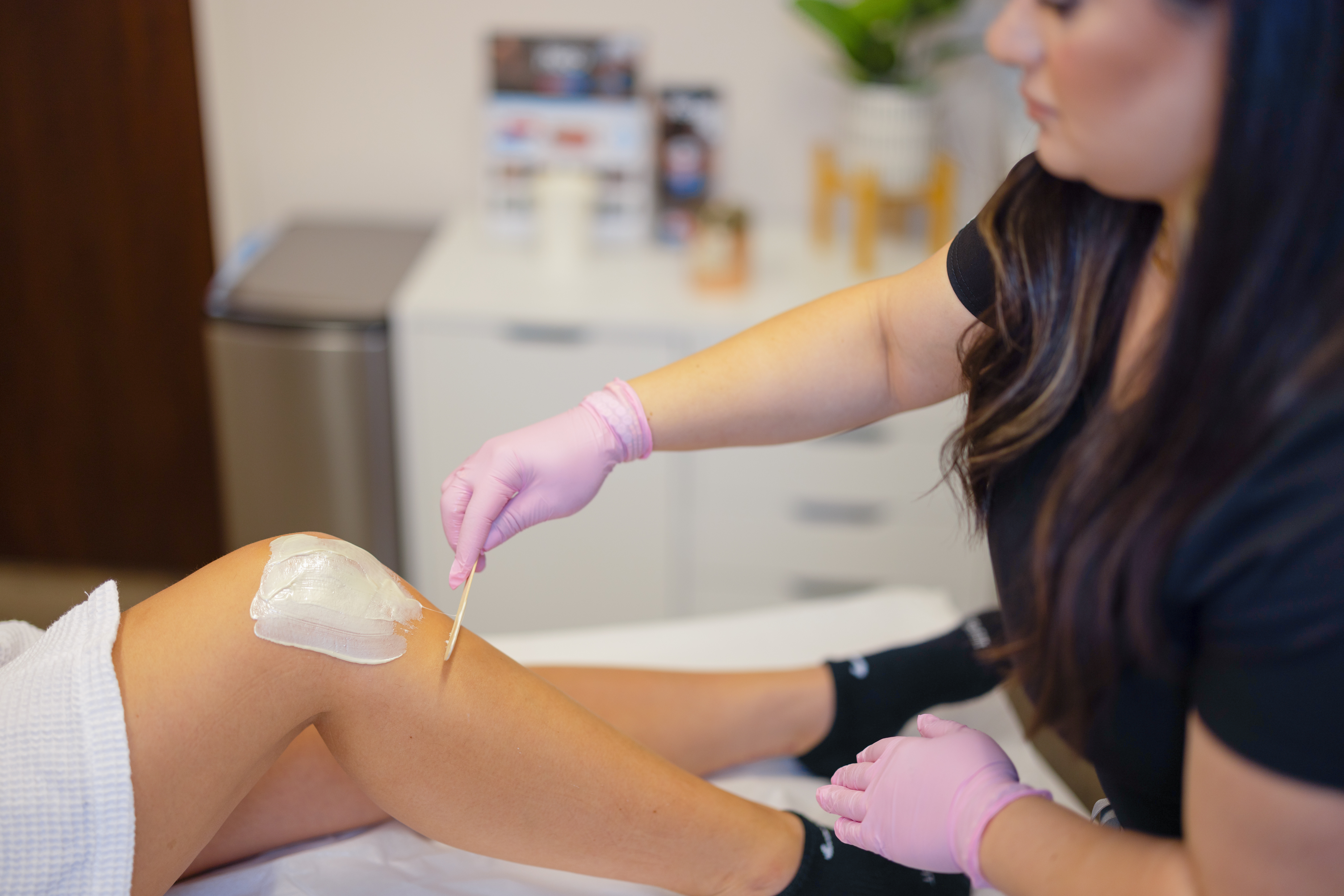 Patient's leg being professionally waxed.