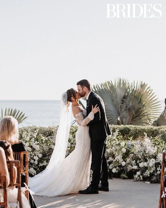 Bride and groom on their wedding day, smiling and holding hands.